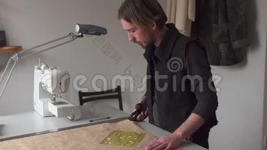 男裁缝工用剪刀剪纸服图案